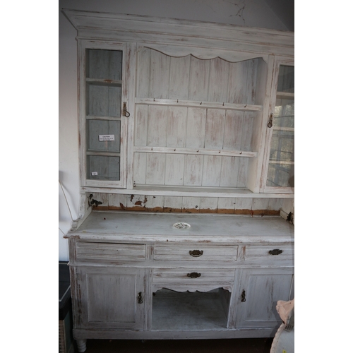 587 - A white painted dresser, the upper section fitted two glazed doors and open shelves over four drawer... 