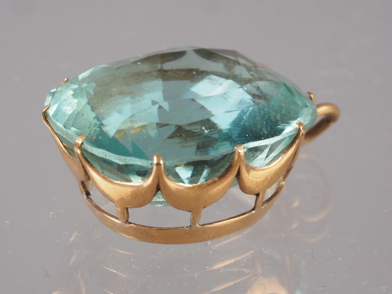 A yellow metal and blue topaz pendant