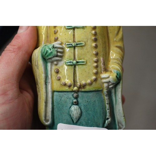 83 - A set of three Chinese yellow, green and brown glazed figures, with stamped marks to bases, 11