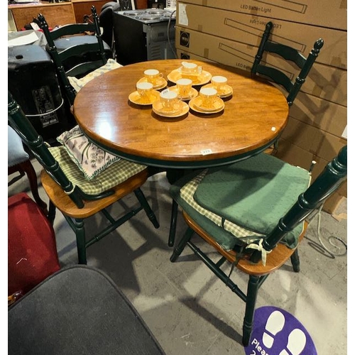 279 - Circular pine and green dining table and four chairs with cushions