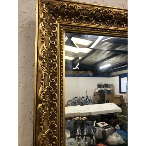 119 - Heavy ornate gold coloured framed bevel edged mirror