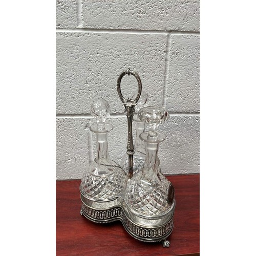 93 - METAL TANTALUS WITH THREE CLEAR GLASS DECANTERS WITH COLLARS