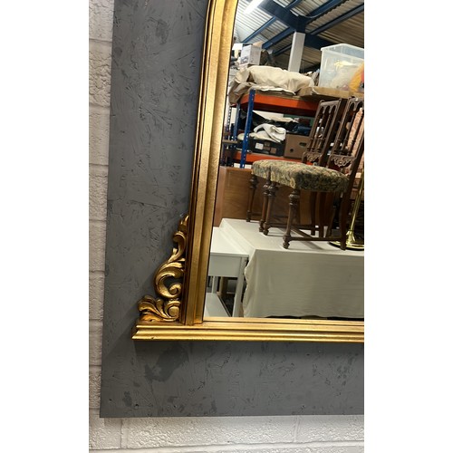 137 - GOLD COLOURED FRAMED ARCH MIRROR