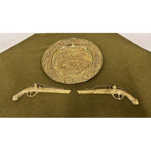 487 - Brassware wall plaque and pistols