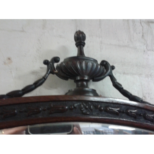 381 - Dark wood oval bevelled glass wall mirror with carved Tudor Rose and ornate finial top