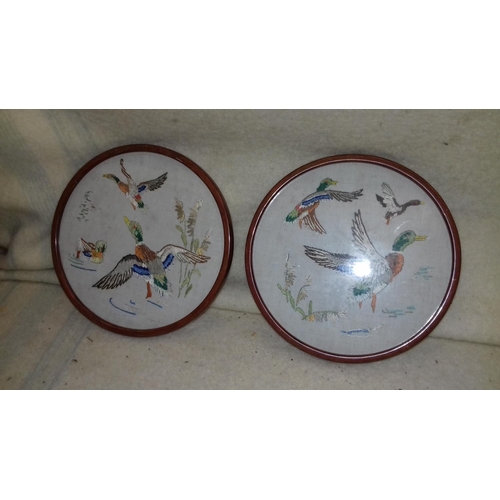 82 - Pair of round 21 cm diameter wooden framed needlework wall plaques of ducks in flight