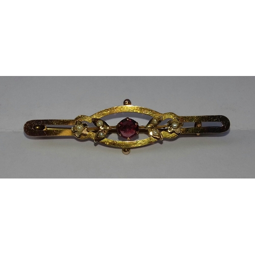 583 - Unstamped but believed to be 9 ct gold, 4.5 cm long ruby and seed pearl bar brooch