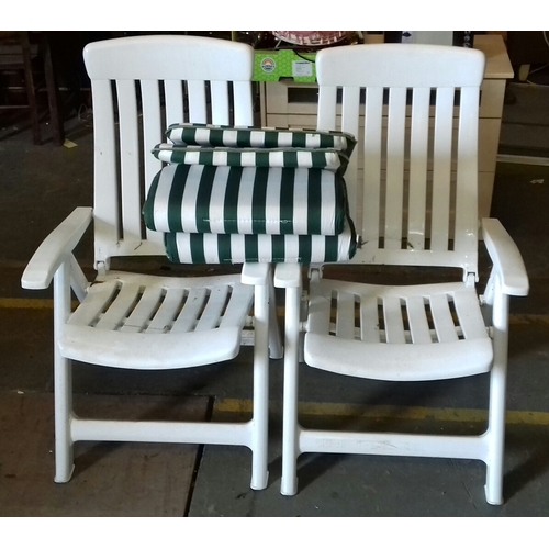 421 - Pair of white plastic garden lounger chairs with cushions