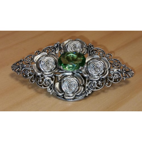 115 - Sterling silver stamped 7 x 4 cm ornate brooch with large green centre stone