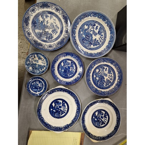 83 - Bundle of assorted old willow blue and white plates etc, some with chips or cracks