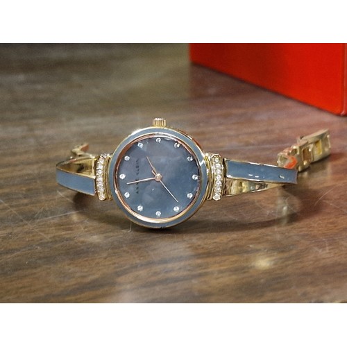 139 - Working ladies Anne Klein jewelled watch with gold tone bangle strap