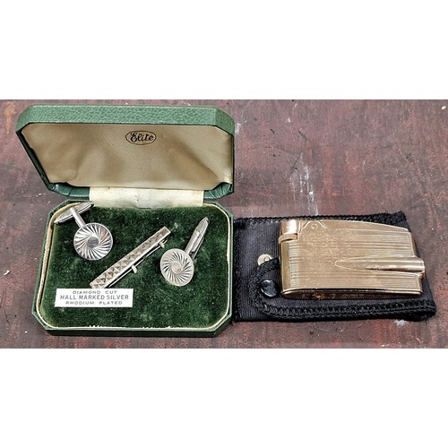 130 - Elite diamond cut rhodium plated cuff links and gold tone Ronson lighter in pouch