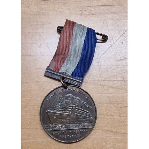 524 - RMS Mauretania medallion with ribbon made from metal from the ship