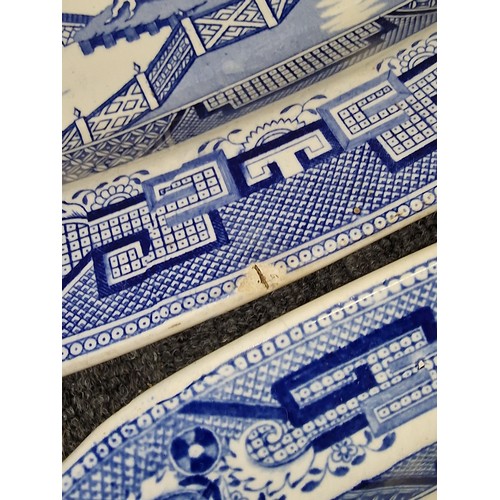 301 - Graduated pair of 19th century willow pattern blue and white chargers, largest with chip on edge