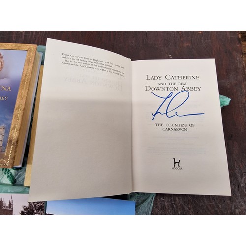 272 - 2 x Downton Abbey first edition books, both signed, 2 x postcards and leather book mark from Highcle... 