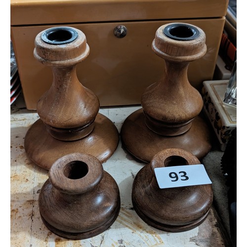 93 - Pair of turned wood candle sticks and similar candle holders