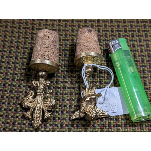 190 - Pair of gilt and cork bottle stoppers being cherub and fleur-de-lys