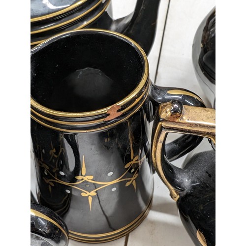 325 - Collection of late 1800s black with gold patterning and detail jugs, bowls and tea pot