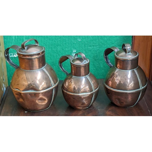 164 - Graduated set of three copper Guernsey cream measuring jugs - all with dents