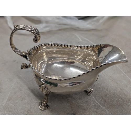 184 - Sheffield hallmarked silver 3 footed sauce/gravy boat in very good condition - 105.8 gm