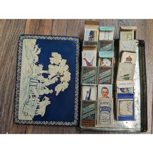 31 - Vintage tin of 1930's cigarette packets with mostly near complete sets of matching cigarette cards