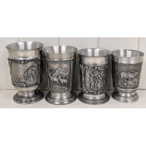25 - Slightly graduated set of 4 x pewter beakers with three embossed picture scenes - tallest 12 cm