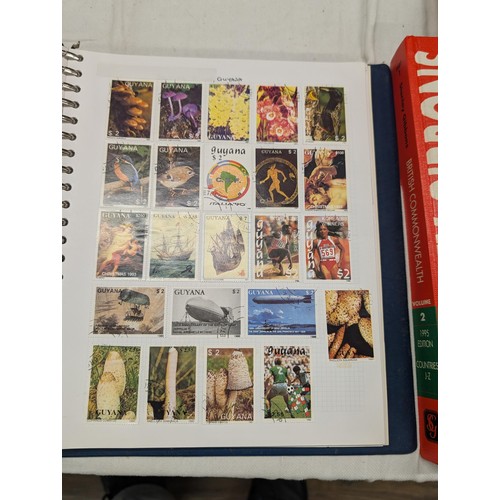 35 - Folder of modern stamps, Stanley Gibbons stamp catalogue and 2 x sheets of WWII christmas greeting a... 