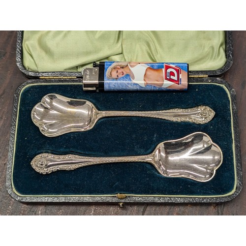 355 - Cased pair of ornate Walker and Hall silver plated spoons