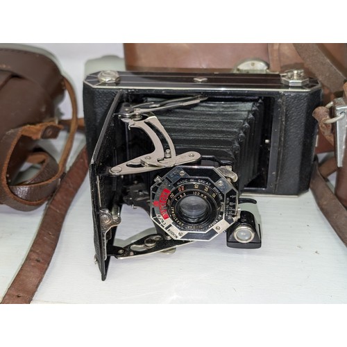 73 - Trio of vintage cameras in cases being Minolta AF-S (in old Ilford case), Kodak folding and Zeiss Ik... 