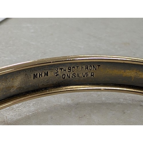 245 - M H Meyer Ltd 9 ct gold front on silver, engine turned fully patterned hinged bangle with safety cha... 