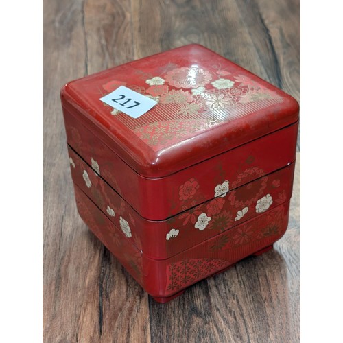 217 - Red lacquer ware stacking jewellery box and contents