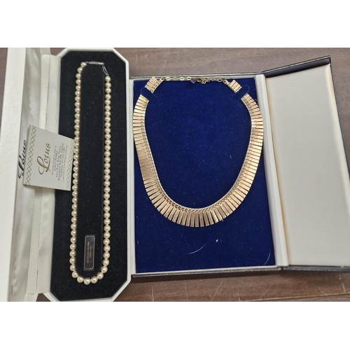 35 - 2 x boxed vintage necklaces (1 being gold tone and the other being pearl)