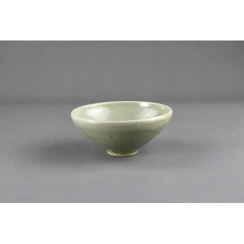 16 - A Yaozhou 'Moon White' Conical Bowl, Five dynasties the deep rounded sides rising from a short strai... 