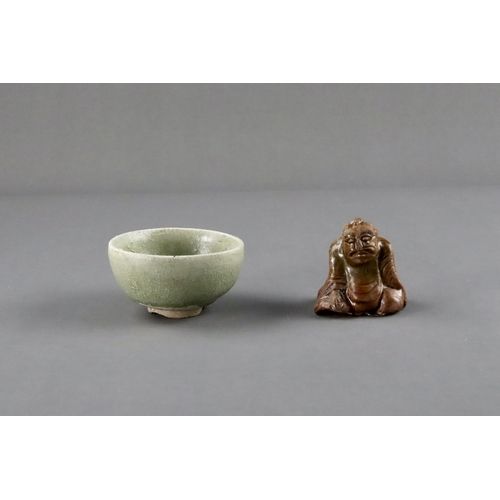 23 - An Amber-glazed Figure and A Celadon Cup, Han dynasty and Sui dynasty a sitting male figure in robe,... 