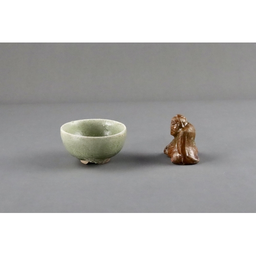 23 - An Amber-glazed Figure and A Celadon Cup, Han dynasty and Sui dynasty a sitting male figure in robe,... 