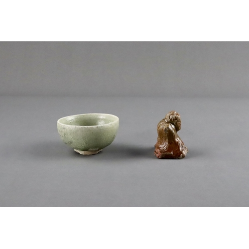 23 - An Amber-glazed Figure and A Celadon Cup, Han dynasty and Sui dynasty a sitting male figure in robe,... 