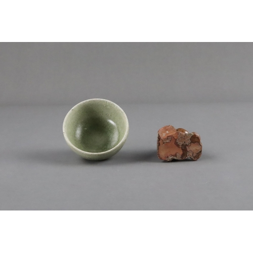 23 - An Amber-glazed Figure and A Celadon Cup, Han dynasty and Sui dynasty a sitting male figure in robe,... 