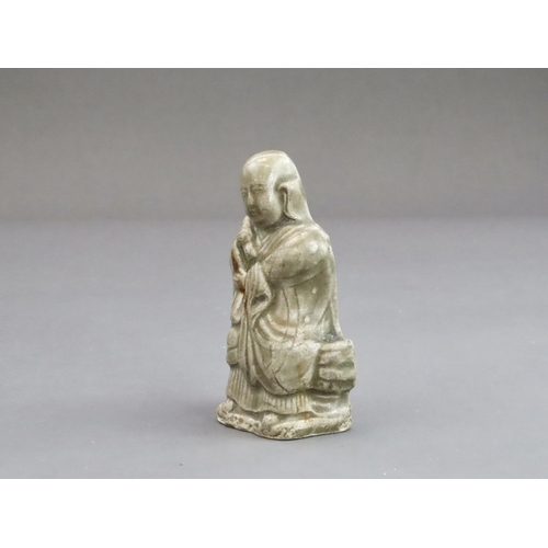 29 - A Rare Miniature Yaozhou Celadon-glazed Figure of a Monk, Song dynasty  The figure wearing long robe... 