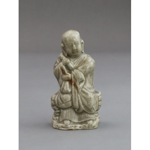 29 - A Rare Miniature Yaozhou Celadon-glazed Figure of a Monk, Song dynasty  The figure wearing long robe... 