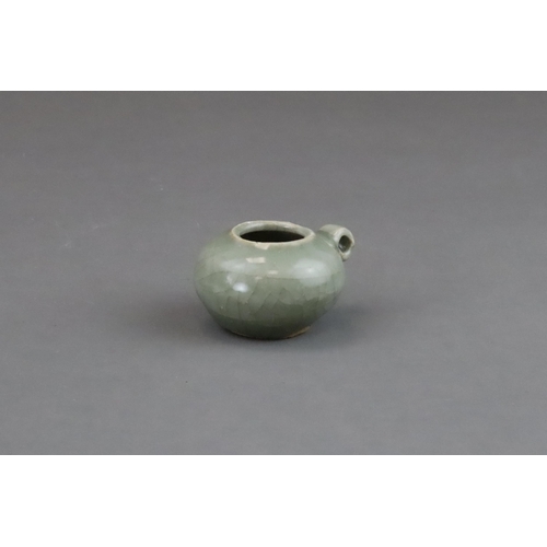 49 - A Longquan Celadon Bird Feeder, Song dynasty of compressed globular form, set with a ring handle at ... 