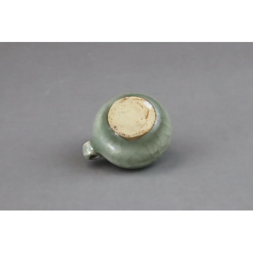 49 - A Longquan Celadon Bird Feeder, Song dynasty of compressed globular form, set with a ring handle at ... 