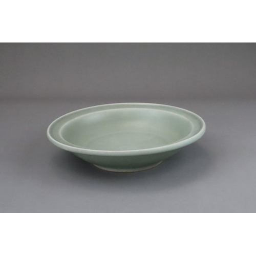 55 - A Longquan Celadon Dish, Song dynasty the shallow rounded sides rising from a short foot to an evert... 