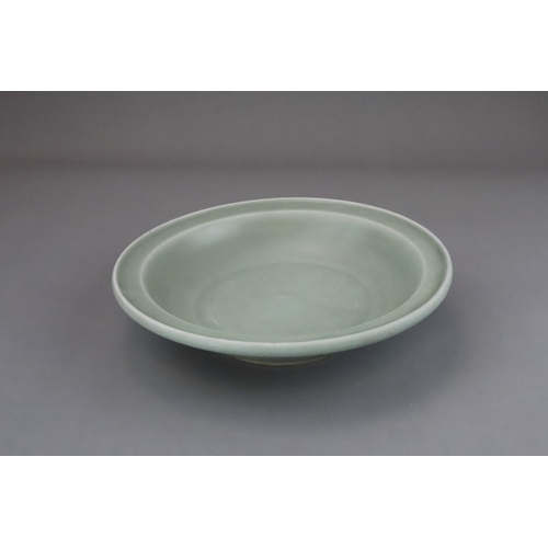 55 - A Longquan Celadon Dish, Song dynasty the shallow rounded sides rising from a short foot to an evert... 