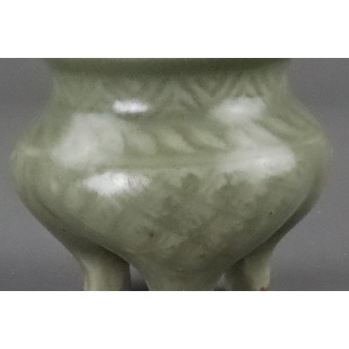 59 - A Carved Longquan Celadon Tripod Incense Burner, early Ming dynasty the compressed body rising from ... 