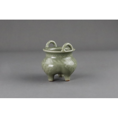 59 - A Carved Longquan Celadon Tripod Incense Burner, early Ming dynasty the compressed body rising from ... 