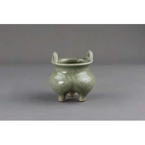 59 - A Carved Longquan Celadon Tripod Incense Burner, early Ming dynasty the compressed body rising from ... 