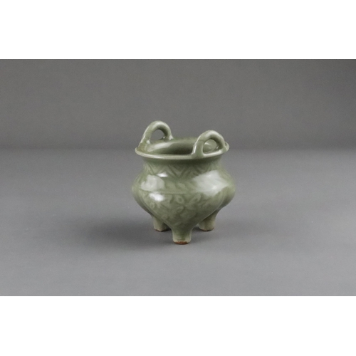 59 - A Carved Longquan Celadon Tripod Incense Burner, early Ming dynasty the compressed body rising from ... 