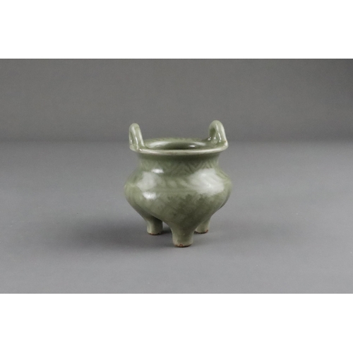 59 - A Carved Longquan Celadon Tripod Incense Burner, early Ming dynasty the compressed body rising from ... 