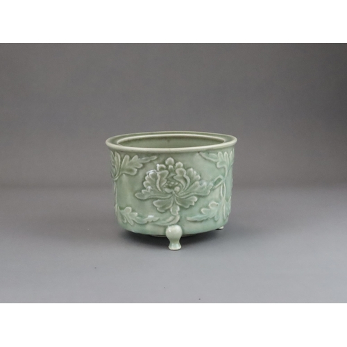 62 - A Longquan Celadon Peony Tripod Censer, early Ming dynasty,   the cylindrical vessel with applied pe... 