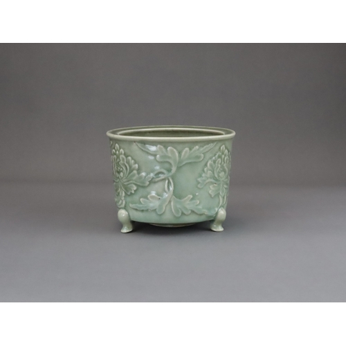 62 - A Longquan Celadon Peony Tripod Censer, early Ming dynasty,   the cylindrical vessel with applied pe... 